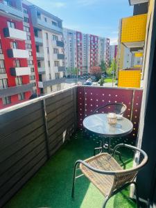 a table and chairs on a balcony with buildings at Home Sweet Home in Braşov