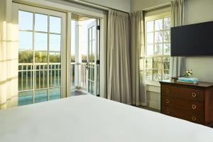 a bedroom with a large bed and large windows at St James Hotel Selma Tapestry Collection by Hilton in Selma