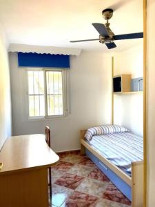 Schlafzimmer mit einem Bett und einem Deckenventilator in der Unterkunft Gransol con piscina 600m playa in Rincón de la Victoria
