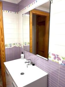 ein Bad mit einem Waschbecken und einem Spiegel in der Unterkunft Gransol con piscina 600m playa in Rincón de la Victoria