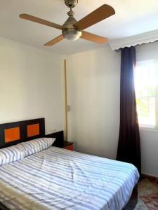 Schlafzimmer mit einem Deckenventilator und einem Bett in der Unterkunft Gransol con piscina 600m playa in Rincón de la Victoria