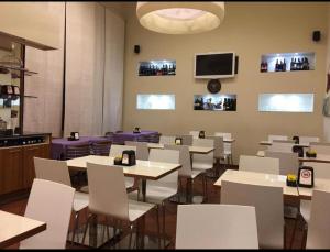 une salle à manger avec des tables et des chaises blanches dans l'établissement Affittacamere San Petronio House, à Bologne