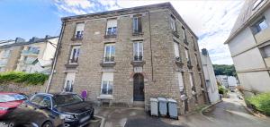 a brick building with a car parked in front of it at Appartement spacieux in Quimper