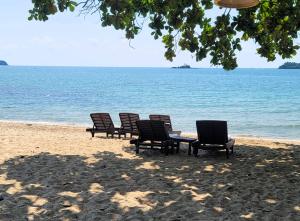eine Reihe von Stühlen am Strand in der Unterkunft Koh Chang Cliff Beach Resort in Ko Chang