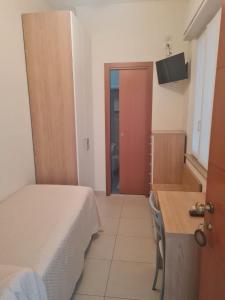 ein kleines Schlafzimmer mit einem Bett und einem Badezimmer in der Unterkunft Hotel Majestic in Senigallia