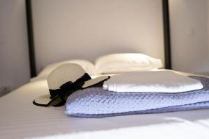 Sombrero y almohada en la cama en LoftLiving 1 by ΑΤΤΙΚΟ ΝΟΣΟΚΟΜΕΙΟ, en Atenas