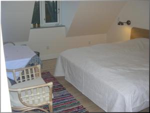 a bedroom with a bed and a chair and a window at Klosterpensionen in Viborg