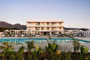 - un grand bâtiment avec une piscine en face dans l'établissement Wyndham Santa Marta Aluna Beach, à Santa Marta