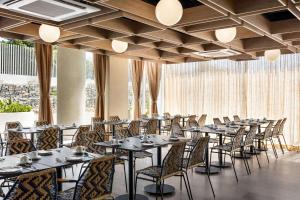 - une rangée de tables et de chaises dans une chambre avec fenêtres dans l'établissement Wyndham Santa Marta Aluna Beach, à Santa Marta