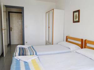 two beds in a room with a door at Apartamentos Font Nova 3000 in Peniscola