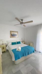 トレ・デル・マールにあるFabuloso apartamento a 50m de playa centricoのベッドルーム1室(大型ベッド1台、シーリングファン付)