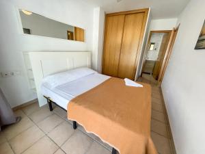 a small bedroom with a bed and a mirror at Apartamentos Font Nova 3000 in Peniscola