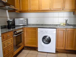 a kitchen with a washing machine and a microwave at Apartamentos Font Nova 3000 in Peniscola