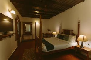 a bedroom with a bed and a television in it at Palmgrove Lake Resort in Alleppey +72 photos