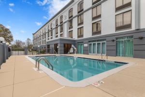 a swimming pool in front of a building at Spark By Hilton Charlotte Tyvola I-77 in Charlotte