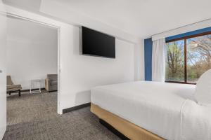 a bedroom with a bed and a flat screen tv at Spark By Hilton Charlotte Tyvola I-77 in Charlotte