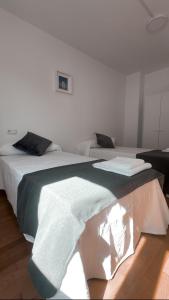 two beds in a white room with at PortoHome I in Portomarin