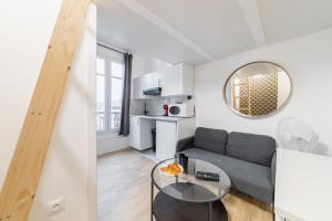 uma sala de estar com um sofá e uma mesa em Studio mezzanine proche Zenith - Paris 19 - 2P em Paris