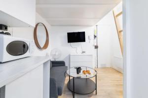 een woonkamer met een tafel en een televisie bij Studio mezzanine proche Zenith - Paris 19 - 2P in Parijs