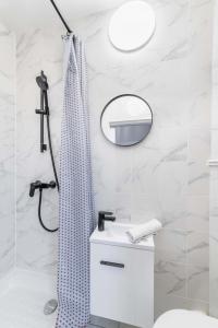 een badkamer met een douche, een wastafel en een spiegel bij Studio mezzanine proche Zenith - Paris 19 - 2P in Parijs