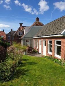 una casa con patio y una casa con césped en Huis in Marrum uit 1880 met grote tuin., en Marrum