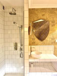 ein Bad mit einer Dusche und einem Waschbecken in der Unterkunft Appartement prestige à deux pas de Montparnasse 6P in Paris