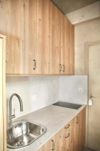 Una cocina con fregadero y armarios de madera. en Studio de charme pour un séjour en amoureux - 2P - FLAT-GUEST, en París