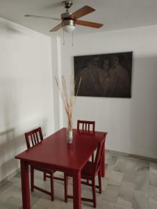 a dining room table with chairs and a ceiling fan at L' Alcoba Rooftop in Sanlúcar de Barrameda