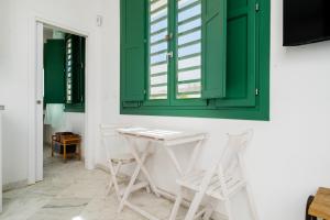 una mesa y sillas en una habitación con armarios verdes en Penthouse con terraza- 2D 2B- Triana, en Sevilla