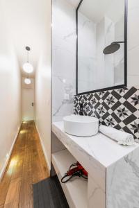 a white bathroom with a sink and a mirror at Séjour romantique avec bain à remous à Pigalle -P6 in Paris