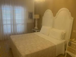 una camera da letto con un grande letto bianco con cuscini bianchi di Hotel Bergamo Mare Mhotelsgroup a San Bartolomeo al Mare