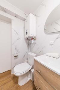 La salle de bains blanche est pourvue de toilettes et d'un lavabo. dans l'établissement Charmant Studio au coeur de La Courneuve - 2P, à La Courneuve