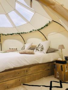 Glamping -Logie Moonlight في براكيل: غرفة نوم بسرير في خيمة
