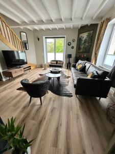 ein Wohnzimmer mit einem Sofa und einem Tisch in der Unterkunft Le Clos Du Pontic Logis et Cit'Hotel in Landerneau