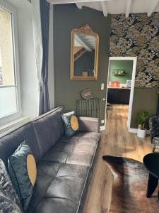 a living room with a couch and a mirror at Le Clos Du Pontic Logis et Cit'Hotel in Landerneau