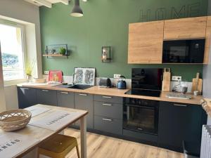 a kitchen with a counter with a stove top oven at Le Clos Du Pontic Logis et Cit'Hotel in Landerneau