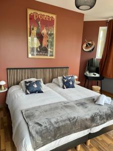a bedroom with two beds and a poster on the wall at Le Clos Du Pontic Logis et Cit'Hotel in Landerneau