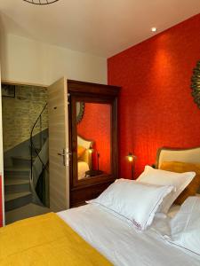 a bedroom with a bed with a red wall at Camélia in Bayeux