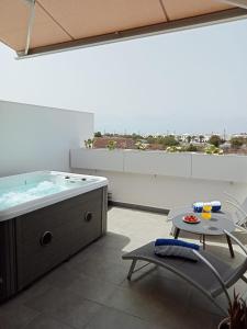a large bathroom with a tub and a table and a table sidx sidx at Nunoli Duplex Luxury Playa Blanca in Playa Blanca