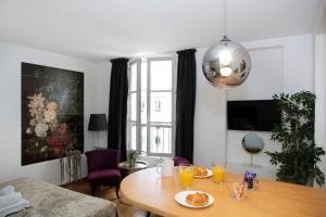 uma sala de estar com uma mesa com comida em 502- Studio de charme dans quartier animé Paris 5 em Paris