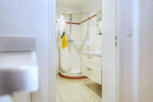 ein weißes Bad mit einer Dusche und einem Waschbecken in der Unterkunft Appartement moderne et élégant a Paris 5 - 4P in Paris