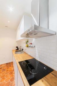 a kitchen with a black counter top and a sink at Jolie 2 pieces 35m2 bien équipée 4P - Paris 20 in Paris
