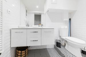 een witte badkamer met een toilet en een wastafel bij Jolie 2 pieces 35m2 bien équipée 4P - Paris 20 in Parijs