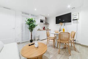 una cucina e un soggiorno con tavolo e sedie di Espace moderne 40m2 a deux pas de Paris - 4P a Les Lilas