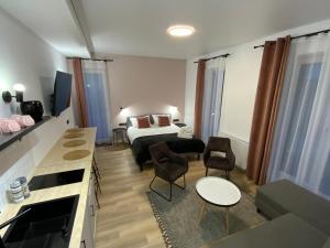 a hotel room with a bed and a table and chairs at Salt Garden Apartments in Druskininkai