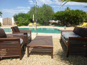 3 chaises et une table à côté de la piscine dans l'établissement Finca Arboleda, à Vera