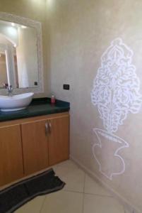 a bathroom with a white stencil of a tree on the wall at palmerais daglou in Tiznit