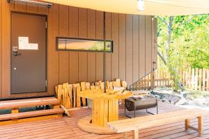 天川村的住宿－CampBaseKadojin - Vacation STAY 73760v，木制庭院设有桌子和长凳,位于甲板上