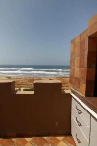 uma vista para a praia a partir da varanda de uma casa em palmerais daglou em Tiznit