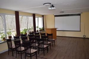 een vergaderzaal met stoelen en een projectiescherm bij Хотел "Загоре" in Starozagorski Bani